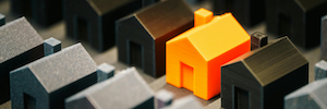Rows of black miniature 3D-printed houses with one bright orange house to provide contrast